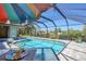 Enjoy the sun in the screened-in private pool area with colorful umbrella and a nice pool-side table set at 2441 Vance Ter, Port Charlotte, FL 33981