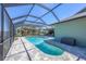 A picturesque screened-in pool with a paved deck offers a serene outdoor retreat, perfect for relaxation and recreation at 2441 Vance Ter, Port Charlotte, FL 33981