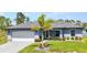 Charming single-story home featuring a well-manicured lawn, palm tree, and attached two-car garage at 2678 Alva St, North Port, FL 34291