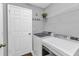 Laundry room with washer, dryer, storage shelf and access to exterior at 2678 Alva St, North Port, FL 34291
