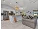 Open-concept living room and kitchen feature granite counters, stainless appliances, and tile floors at 2678 Alva St, North Port, FL 34291