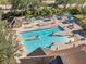 An aerial view shows the community pool, hot tub, umbrellas and lounge seating at 2692 Wax Myrtle Ct, Port Charlotte, FL 33953