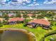 Aerial view of homes with screened lanais overlooking a pond in a lush, green community at 2692 Wax Myrtle Ct, Port Charlotte, FL 33953