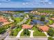 Scenic view of a house with a tile roof and long driveway in a lakeside community with lush landscaping at 2692 Wax Myrtle Ct, Port Charlotte, FL 33953