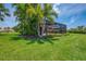 Expansive backyard with a screened lanai, lush lawn, and tropical landscaping, perfect for outdoor living at 2692 Wax Myrtle Ct, Port Charlotte, FL 33953