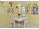 Cheerful dining area featuring a round table, white chairs, and bright yellow walls with whimsical decor at 2692 Wax Myrtle Ct, Port Charlotte, FL 33953