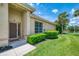 A welcoming home exterior with well-kept lawn, lush landscaping, and a view of the pond at 2692 Wax Myrtle Ct, Port Charlotte, FL 33953