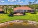 Beautiful home exterior featuring a screened lanai and lush landscaping overlooking a serene pond at 2692 Wax Myrtle Ct, Port Charlotte, FL 33953