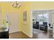A brightly lit foyer with yellow walls and dark wooden floors leading to a living area at 2692 Wax Myrtle Ct, Port Charlotte, FL 33953