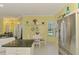 Bright kitchen with granite countertops, stainless steel refrigerator, breakfast nook, and easy access to other areas at 2692 Wax Myrtle Ct, Port Charlotte, FL 33953