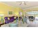 An inviting living space featuring a vibrant purple couch and serene view of the screened outdoor patio at 2692 Wax Myrtle Ct, Port Charlotte, FL 33953