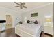Main bedroom with wood floors, white furniture, and calming paint colors with a ceiling fan at 2692 Wax Myrtle Ct, Port Charlotte, FL 33953