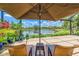 Relax under an umbrella on a screened patio enjoying views of the lake at 2692 Wax Myrtle Ct, Port Charlotte, FL 33953