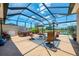 Wide view of screened in patio with multiple seating areas and lovely lake view at 2692 Wax Myrtle Ct, Port Charlotte, FL 33953
