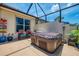 The backyard's screened patio includes a hot tub, seating and vibrant plants at 2692 Wax Myrtle Ct, Port Charlotte, FL 33953