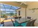 Outdoor patio featuring a screened enclosure, water view, ceiling fan and outdoor seating at 2692 Wax Myrtle Ct, Port Charlotte, FL 33953