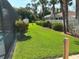 Well-maintained backyard showcasing lush green grass, vibrant plants, and a partial pool view at 2864 Traverse Ave, North Port, FL 34286