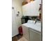 Laundry room with white washer and dryer, storage cabinets, and door to the outside at 2864 Traverse Ave, North Port, FL 34286