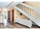 Inviting hallway with daybed, white staircase, and wood-style floors, showcasing modern design at 301 S Gulf Blvd # 3, Placida, FL 33946