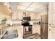 Well-lit kitchen featuring stainless steel appliances, granite countertops, and light wood cabinets at 301 S Gulf Blvd # 3, Placida, FL 33946