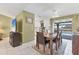 Bright dining room with wood table, tile flooring, and pool views through a large window at 3025 Curry Ter, Port Charlotte, FL 33981