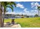 Scenic view of a dock with a boat lift, landscaping, and a mermaid statue overlooking the water at 3025 Curry Ter, Port Charlotte, FL 33981