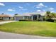 Charming single-story home with well-manicured lawn, mature landscaping and attached garage under a partly cloudy sky at 3025 Curry Ter, Port Charlotte, FL 33981