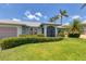 Charming single-story home with well-manicured lawn, mature landscaping and attached garage under a partly cloudy sky at 3025 Curry Ter, Port Charlotte, FL 33981