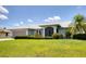 Charming single-story home with well-manicured lawn, mature landscaping and attached garage under a partly cloudy sky at 3025 Curry Ter, Port Charlotte, FL 33981