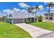 Charming single-story home with a well-manicured lawn, a long driveway and beautiful palm trees at 3025 Curry Ter, Port Charlotte, FL 33981