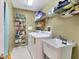 Functional laundry room with washer, dryer, utility sink, and ample shelving for storage at 3025 Curry Ter, Port Charlotte, FL 33981