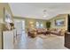 Inviting living room with tile flooring, neutral walls, ceiling fan, comfortable seating, and natural light from large windows at 3025 Curry Ter, Port Charlotte, FL 33981
