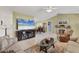 Bright living room with tile flooring, neutral walls, ceiling fan, comfortable seating, and a view to kitchen and dining area at 3025 Curry Ter, Port Charlotte, FL 33981