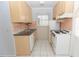 Functional kitchen featuring tiled floors, white appliances and light wood cabinets at 407 Park S Blvd, Venice, FL 34285