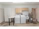 Bright laundry room with white appliances, built-in storage cabinets, and a utility sink for added convenience at 407 Park S Blvd, Venice, FL 34285
