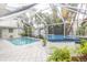 View of the pool and hot tub with tropical landscaping in screened in lanai at 407 Park S Blvd, Venice, FL 34285