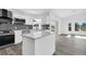 Bright kitchen with stainless appliances, white cabinets, island, and mosaic backsplash at 4210 Day St, Port Charlotte, FL 33948