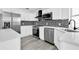 Modern kitchen with stainless appliances, white cabinets, quartz counters, and mosaic backsplash at 4210 Day St, Port Charlotte, FL 33948