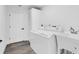 Bright laundry room with modern appliances, built-in cabinet and grey wood-look flooring at 4210 Day St, Port Charlotte, FL 33948