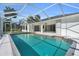 Backyard view showcasing an in-ground pool with an enclosed screen at 4210 Day St, Port Charlotte, FL 33948