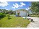 A large garage sits beside an artificial putting green and a grassy yard with clear blue skies at 4510 Burns Ter, Port Charlotte, FL 33981