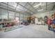A spacious garage interior featuring a lawn mower, workbench, shelves, and a storage area at 4510 Burns Ter, Port Charlotte, FL 33981