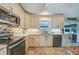 Modern kitchen featuring cream-colored cabinetry, stainless steel appliances, and decorative tile backsplash at 4510 Burns Ter, Port Charlotte, FL 33981