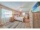 Bright primary bedroom features a ceiling fan, wood-look tile flooring, and serene decor at 4510 Burns Ter, Port Charlotte, FL 33981