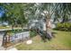 Exterior shot of the outbuilding surrounded by landscaping, wrought iron fence, and an adjacent wood work area at 4510 Burns Ter, Port Charlotte, FL 33981