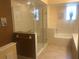 Well-lit bathroom with tile floors featuring a glass shower and separate tub at 4612 Club Dr # D102, Port Charlotte, FL 33953