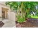 Inviting home entrance with a glass front door, tropical landscaping, and a view of the nearby water at 4612 Club Dr # D102, Port Charlotte, FL 33953