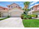 Beautiful two-story villa with a terra cotta roof, multi-car garage, and vibrant landscaping at 4612 Club Dr # D102, Port Charlotte, FL 33953