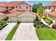 Beautiful two-story villa with a terra cotta roof, multiple car garage, and tropical landscaping at 4612 Club Dr # D102, Port Charlotte, FL 33953
