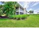 Beautiful two-story home with a screened lanai and lush landscaping enhancing the property's curb appeal at 4612 Club Dr # D102, Port Charlotte, FL 33953